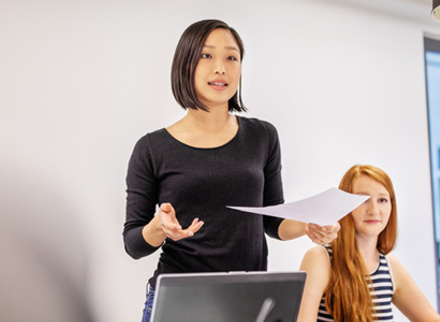 Woman giving presentation to work colleagues