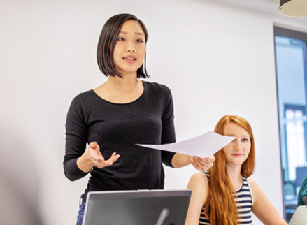 Woman giving presentation to work colleagues