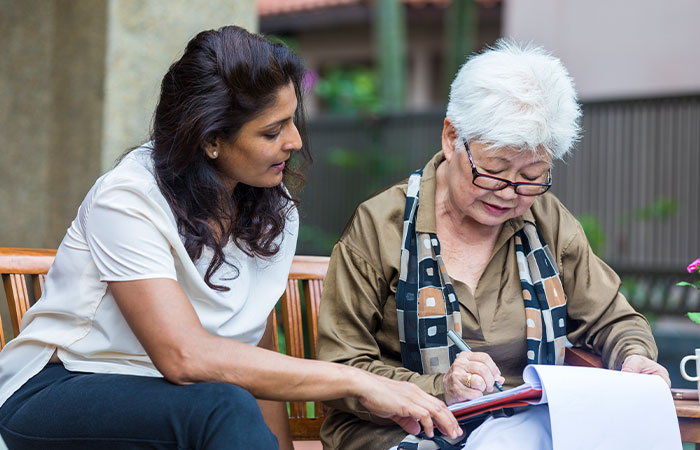 younger-woman-helping-older-woman-with-forms.jpg