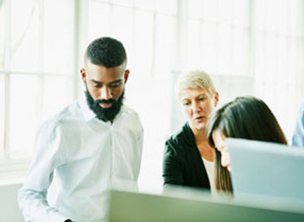 A woman discussing with two of her colleagues 