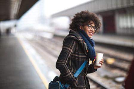 Woman smiling while waiting at the train station 