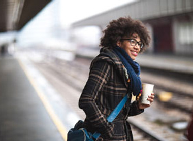 Woman smiling while waiting at the train station 