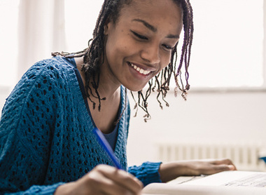 Woman looking over notes whilst smiling