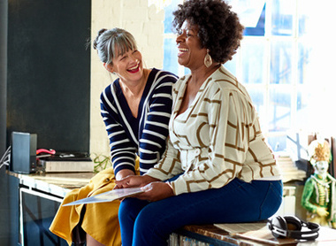 Two women at work talking and laughing