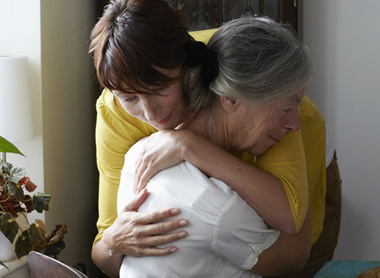 Young woman hugging elderly woman