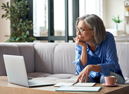 Older woman at work looking out of window and smiling